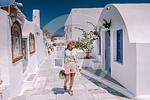 Sunset at the Island Of Santorini Greece, beautiful whitewashed village Oia with church and windmill during sunset Woman