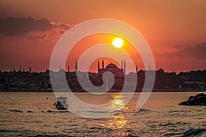 Sunset in istanbul, silhouette of the historical peninsula. Sunset over Hagia Sophia and Historical Peninsula. Fishing boat