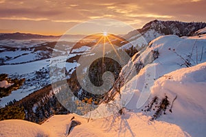 Sunset from Janosikov stol rock over Liptovska Anna village in Chocske vrchy mountains during winter