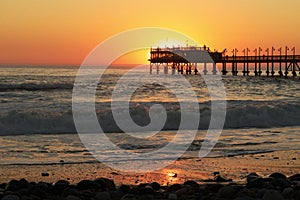 Sunset jetty/Pier in ocean with waves.