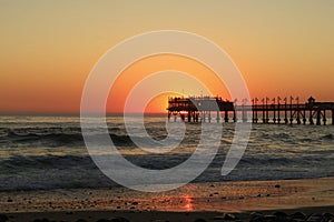 Sunset jetty/Pier in ocean with waves.