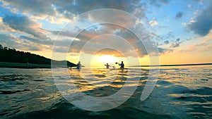 Sunset lake with boaters canoeing in slow motion