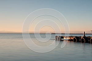 Sunset on a lake with an empty jetty and feeling of calm in the coastal lagoon of Valencia