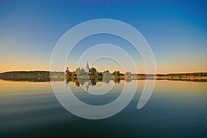 Sunset on the lake. Monastery with reflection in blue water