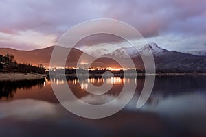 Sunset on the lake with the reflection of mountains