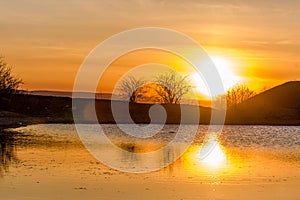 Sunset, on the lake, reflection, water and the rays of the sun.