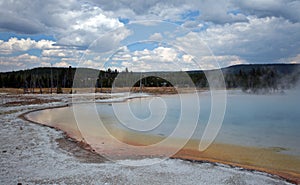 Sunset Lake under dark cumulus clouds in Black Sand Basin in Yellowstone National Park in Wyoming USA