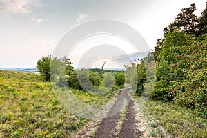 Sunset landscape panorama, hills in golden hour, small village in valley, beautiful colors and clouds.