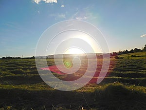 Sunset Landscape photo of a green freshly cut hay grass filed