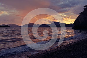 Sunset landscape, seashore, waves in the rays of the setting sun