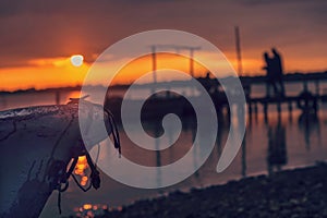 Sunset landscape with a silhouette of couples on a quay, outdoor