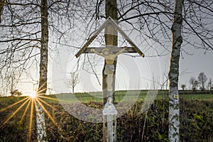 Sunset and last sunbeams with a way cross in the Bavarian forest