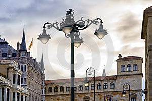 Sunset in Leon with gothic buildings and large wrought iron street lamps. photo