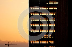 Sunset light going through skeleton of dismantled building. Deconstruction of old office skyscraper.