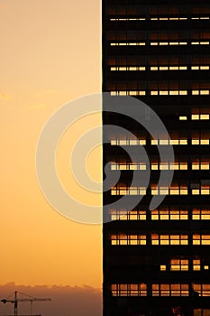 Sunset light going through skeleton of dismantled building. Deconstruction of old office skyscraper.