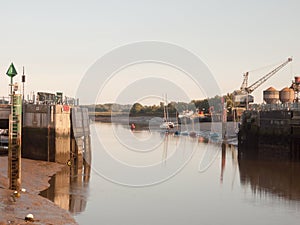 Sunset light scene over dock gate open with moored boats river