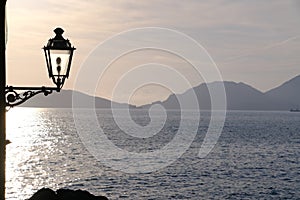 Sunset light on the sea of the Gulf of La Spezia. Street lamp in the marine village of Tellaro, near the CinqueTerre