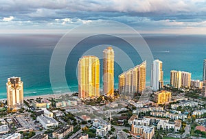 Sunset lights over Miami Beach buildings, helicopter view