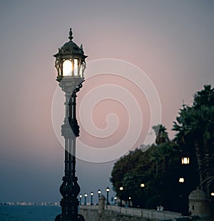 Sunset and a lonely lamppost at the avenida Campo del Sur in Cadiz Spain photo