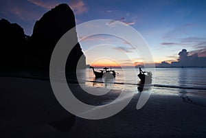 Sunset with longtail boat silhouette in Railay beach, Krabi - Thailand