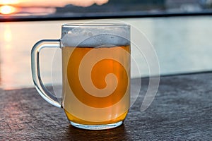 Sklenice studeného světlého piva s pěnou, tradiční slovenský nápoj
