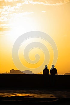 Sunset and lovers. Woman and man against the backdrop of sunset. Orange sky a