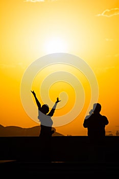 Sunset and lovers. Woman and man against the backdrop of sunset. Orange sky a