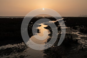 Sunset at low tide on a misty day in autumn