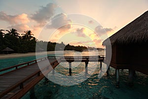 Sunset on Maldives island, water villas resort