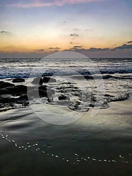 Sunset on Mandrem Beach in Goa, India. Bright and colorful sunset over the Indian Ocean, the Arabian Sea. A tropical