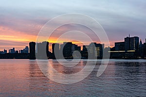 Sunset of Manhattan Skyline in New York City. Silhouette of skyscrapers along East River