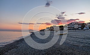 Sunset on a Mediterranean beach of Ionian Sea with Mount Etna Volcano on background - Bova Marina, Calabria, Italy