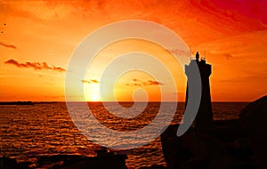 Sunset at Men ruz lighthouse at Pink Granite coast in Brittany