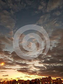 Sunset and moon with cloudy skies photo