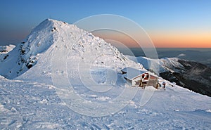 Západ slnka v horách s alpskou chatou