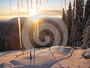 Sunset in the mountains at the icy window