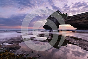 Sunset near famous tourist landmark of Bali island - Tanah Lot & Batu Bolong temple.