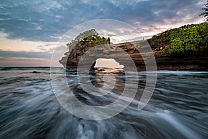 Sunset near famous tourist landmark of Bali island - Tanah Lot & Batu Bolong temple.