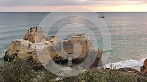 Sunset on the ocean, coast of Portugal, famous cliffs and caves, beach, ship, waves, beautiful clouds