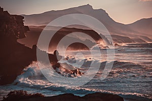 Sunset. ocean landscape. Rocks and wave with fog