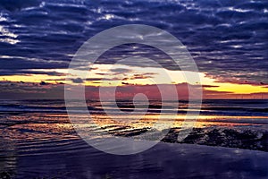 Sunset at the ocean, with the sky reflecting in the water. Egmond aan Zee, Netherlands