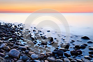 Sunset ocean stones background Baltic Sea coast