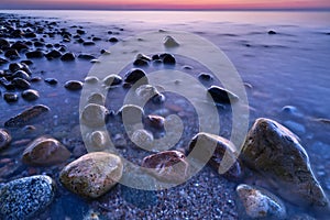 Sunset ocean stones. Baltic Sea coast, Poland.