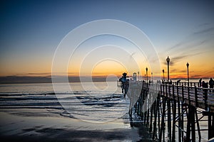 Sunset by Oceanside Pier, Palms and the Pacific Oceanin the famous surf city in California USA