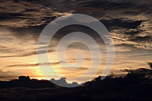 Sunset in the open ocean. Colorful views of the surface of the water and the sky with clouds over ocean.