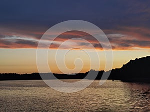 Sunset with orange clouds over the river