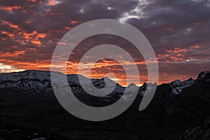 Sunset with orange clouds over snowy mountains of the Cantabrian mountains photo