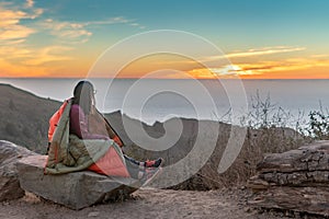 Girl Wrapped in Blanket while watching sunset