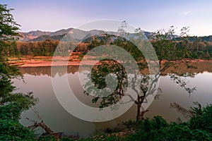 Sunset outside Luang Prabang. Sun shins on an old village. Jungle around the village. Nam khan river infront of the old village.