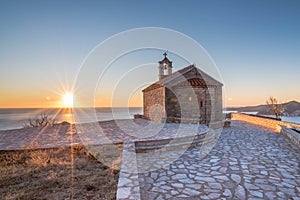 Sunset over the Adratic sea in Montenegro, Serbian Orthodox Church Sveti Sava. view from the top of the mountain above St. Stephen